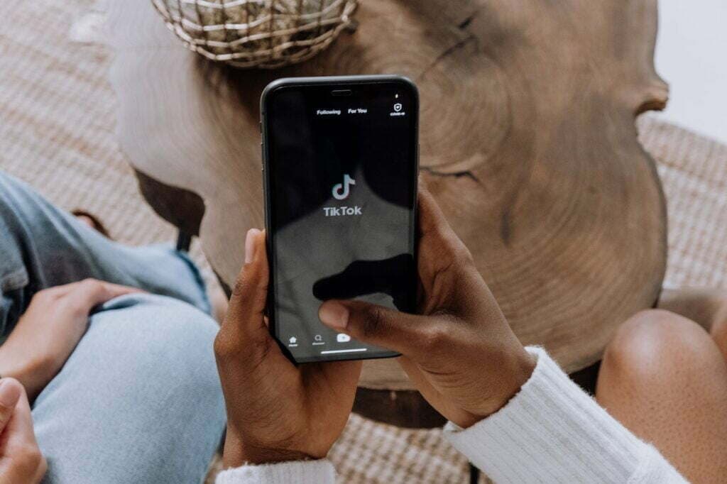 Femme tenant son téléphone montrant la plateforme TikTok - Guadeloupe